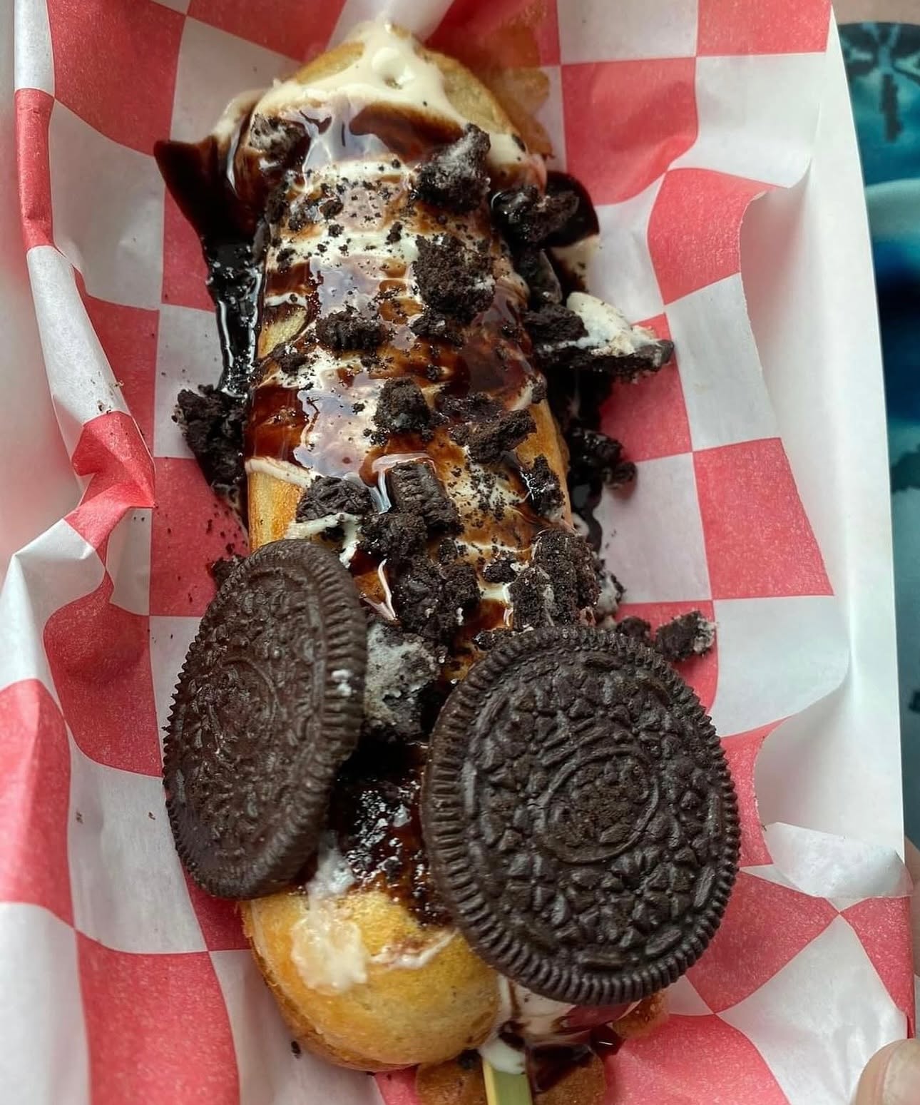 A loaded churro topped with cookies and cream, chocolate drizzle and Oreo