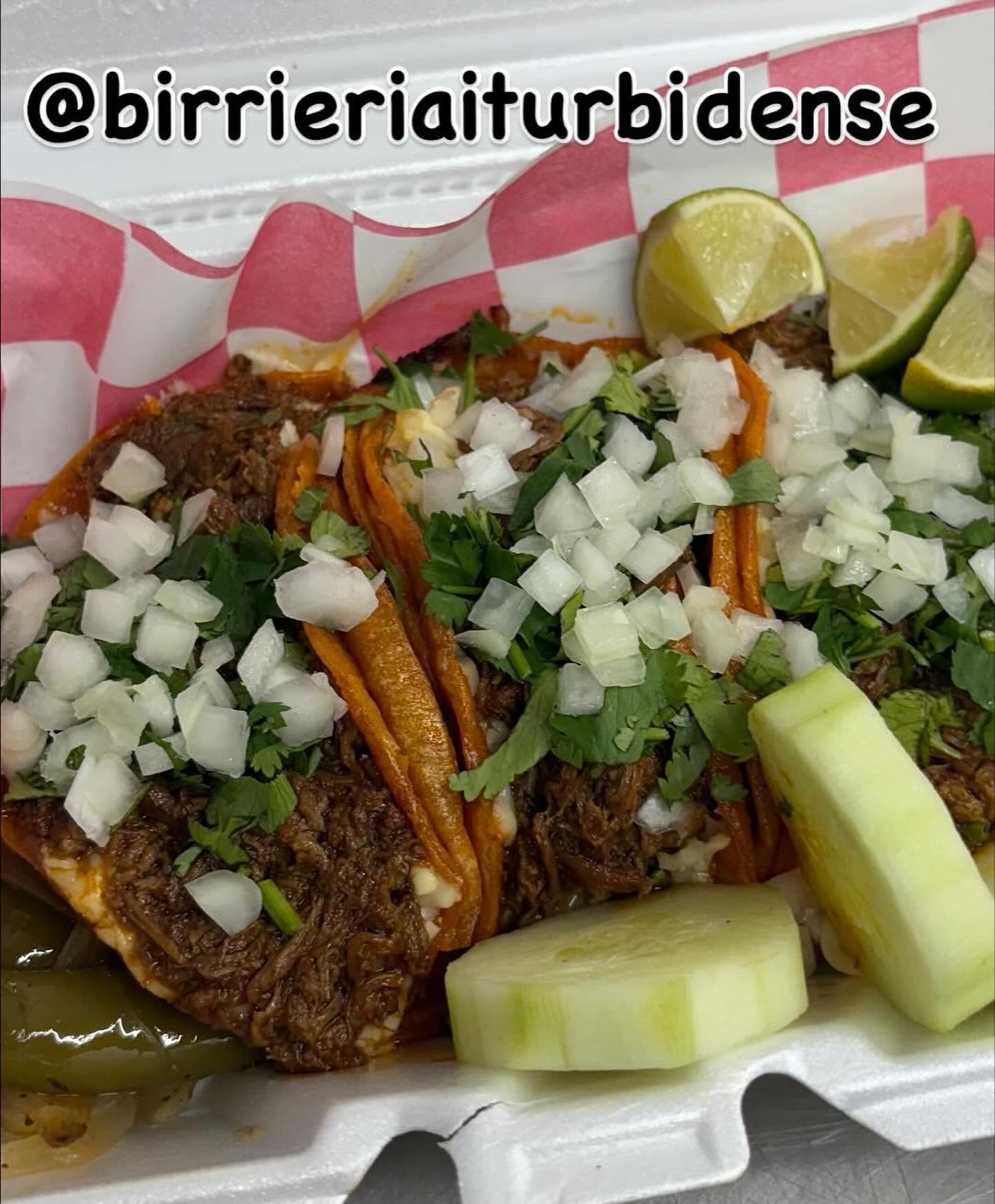 Vibrant consommé-dipped quesabirria tacos topped with onion and cilantro